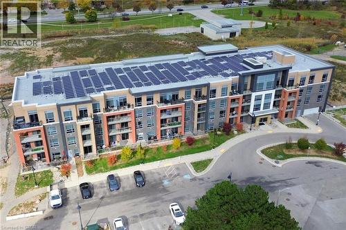 Contemporary multi-story building featuring extensive rooftop solar panel installations - 4040 Upper Middle Road Unit# 105, Burlington, ON 