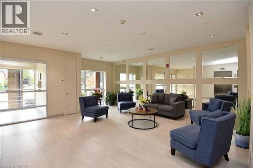 Spacious common area featuring recessed lighting, a grid of wall-mounted mirrors, large format tile flooring, and abundant natural light from expansive windows - 4040 Upper Middle Road Unit# 105, Burlington, ON 
