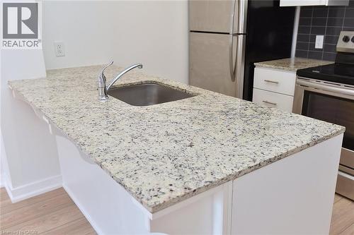 Kitchen island featuring a stainless steel undermount sink and chrome faucet - 4040 Upper Middle Road Unit# 105, Burlington, ON 