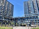 Modern high-rise residential building featuring a dark facade with geometric yellow accents - 4878 Powers Common Unit# C-1105, Burlington, ON 