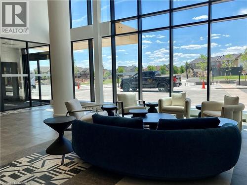 Spacious lobby featuring floor-to-ceiling windows, high ceilings, a decorative tile inlay, and a modern entryway with glass doors - 4878 Powers Common Unit# C-1105, Burlington, ON 