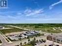 Expansive urban landscape featuring commercial structures, paved roadways, and undeveloped green spaces - 4878 Powers Common Unit# C-1105, Burlington, ON 