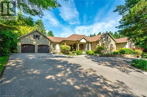 View of front of house with stone siding, aphalt driveway, and an attached garage - 18 Westie Road, Brantford, ON 