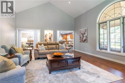 Living area with baseboards, high vaulted ceiling, visible vents, and wood finished floors - 18 Westie Road, Brantford, ON 