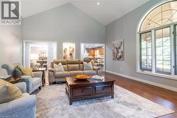 Living area with baseboards, high vaulted ceiling, visible vents, and wood finished floors - 