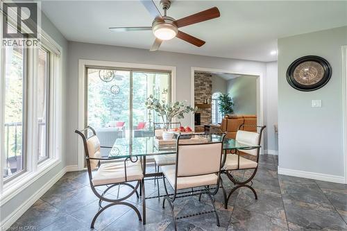 Dining space with a ceiling fan, baseboards, a fireplace, and a wealth of natural light - 18 Westie Road, Brantford, ON 