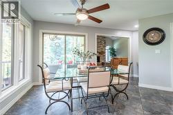 Dining space with a ceiling fan, baseboards, a fireplace, and a wealth of natural light - 
