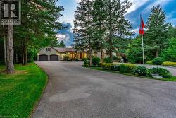 View of front of house featuring stone siding, an attached garage, aphalt driveway, and a front yard - 