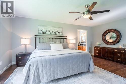 Bedroom featuring ensuite bathroom, baseboards, and wood finished floors - 18 Westie Road, Brantford, ON 