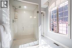 Bathroom featuring marble finish floor, a shower stall, baseboards, and visible vents - 