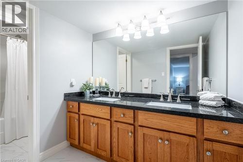 Full bathroom with marble finish floor, a sink, double vanity, and baseboards - 18 Westie Road, Brantford, ON 