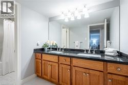 Full bathroom with marble finish floor, a sink, double vanity, and baseboards - 