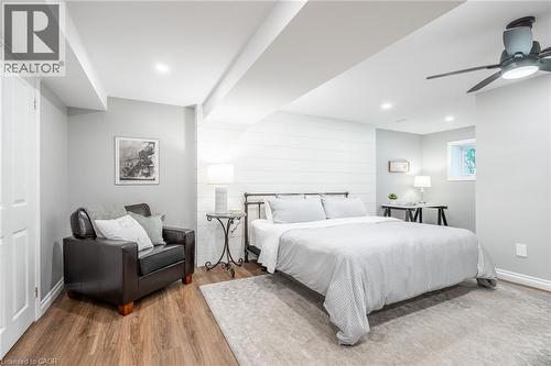 Bedroom featuring wood walls, recessed lighting, baseboards, ceiling fan, and wood finished floors - 18 Westie Road, Brantford, ON 