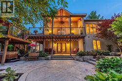 Rear view of property featuring stucco siding, stairs, a hot tub, french doors, and a patio - 