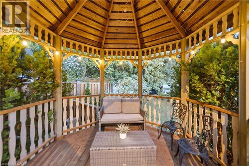 Wood-finish gazebo featuring a latticed ceiling, built-in wooden decking, and decorative spindle railings - 7775 St. Augustine Crescent, Niagara Falls, ON 
