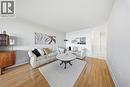 Spacious living area featuring wood-finish flooring, light-toned walls, and a textured ceiling - 2055 Upper Middle Road Unit# 602, Burlington, ON 