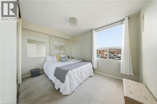 Bedroom featuring a large window, light-toned walls, and wall-to-wall carpeting - 2055 Upper Middle Road Unit# 602, Burlington, ON 