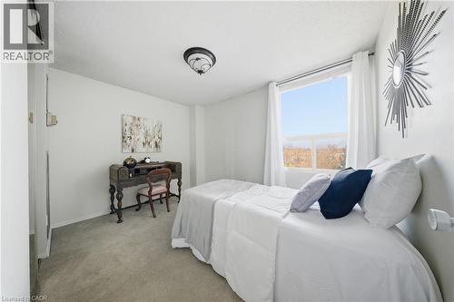 Room featuring light gray carpet flooring, white walls, and a prominent window - 2055 Upper Middle Road Unit# 602, Burlington, ON 