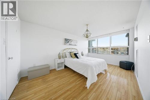 Room featuring light wood-finish flooring, white walls, and a large window with a distant landscape - 2055 Upper Middle Road Unit# 602, Burlington, ON 