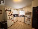 Kitchen with white cabinetry, tile flooring, a window above the sink, and a tile backsplash - 105 Marshall Street, Waterloo, ON 