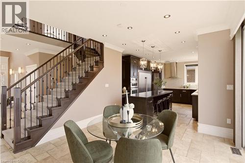 Open-concept living area featuring a grand staircase with dark wood newel posts and iron balusters, recessed lighting, and crown molding - 15 Mcwilliams Court, Cambridge, ON - Indoor Photo Showing Dining Room