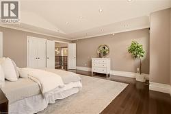 Spacious room featuring wood-finish flooring, recessed ceiling lighting, crown molding, double doors, and wide baseboards - 