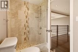 Tiled shower enclosure featuring a glass panel, integrated shelving, and a mosaic floor - 