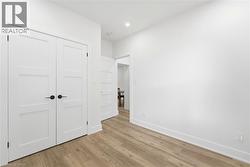 Interior room featuring light wood-finish flooring and crisp white walls - 