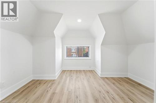 Attic space with sloped ceilings and light wood-finish flooring - 968 Main Street E, Hamilton, ON 