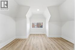 Attic space with sloped ceilings and light wood-finish flooring - 