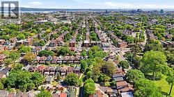 Expansive aerial perspective showcasing a residential area with a mix of architectural styles, tree-lined streets, and open green spaces - 