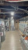 Utility room featuring multiple electrical panels, two water heaters, and two furnaces - 