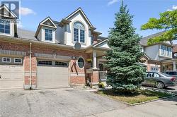 Brick facade townhome with a single-car garage and additional exterior parking - 