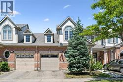 Brick and siding exterior featuring arched and dormer windows, an attached garage, and a covered entry - 