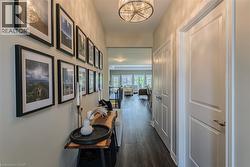 Hallway featuring wood-finish flooring and a contemporary drum pendant light fixture - 