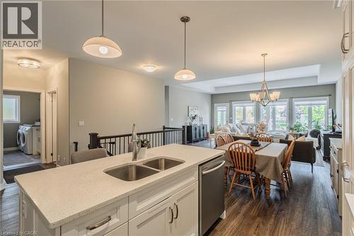 Kitchen island with a double stainless steel sink and light-colored countertop - 15 Winterberry Lane, Waterford, ON 