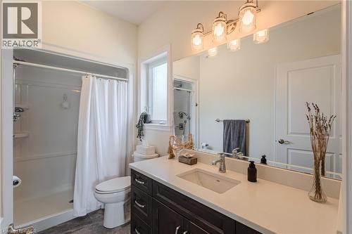 Bathroom featuring a spacious vanity with a light-toned countertop, an undermount sink, and dark wood-finish cabinetry - 15 Winterberry Lane, Waterford, ON 