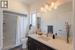Bathroom featuring a spacious vanity with a light-toned countertop, an undermount sink, and dark wood-finish cabinetry - 