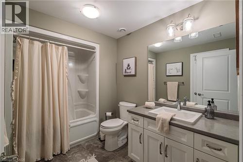 Bathroom featuring a white vanity with multiple cabinets and drawers, a rectangular undermount sink, and a gray countertop - 15 Winterberry Lane, Waterford, ON 