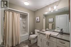 Bathroom featuring a white vanity with multiple cabinets and drawers, a rectangular undermount sink, and a gray countertop - 