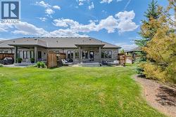 Expansive green lawn with mature trees bordering the property - 