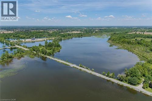 Expansive body of water bordered by lush green foliage and distant agricultural fields - 15 Winterberry Lane, Waterford, ON 
