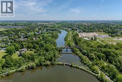 Aerial perspective featuring a river, surrounding green spaces, and a bridge - 