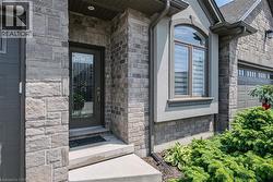 Stone and brick facade featuring a decorative glass entry door with sidelights - 