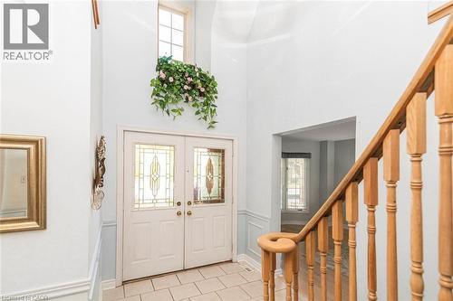 Grand entryway featuring a double door with decorative glass inserts, a transom window, and a two-story ceiling - 85 Citation Crescent, Ancaster, ON 