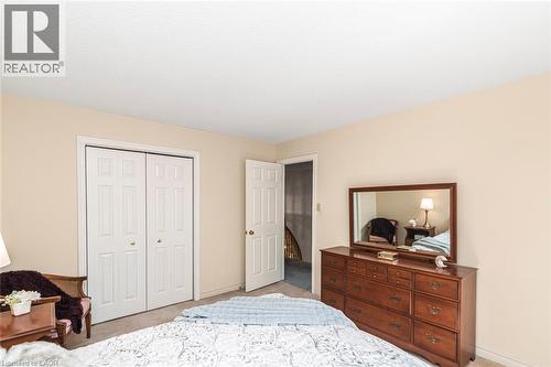 Neutral-toned bedroom with textured carpeting and two-panel bi-fold closet doors - 85 Citation Crescent, Ancaster, ON 