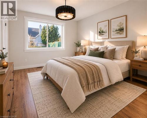 Bedroom featuring wood-finish flooring, a contemporary drum pendant light fixture, and a large window with white trim - 204 Glow Avenue Unit# Upper, Hamilton, ON 