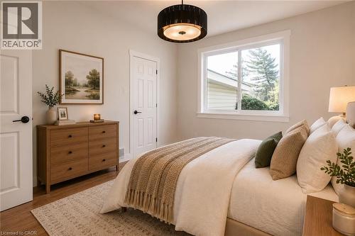 Spacious room featuring wood-finish flooring, a contemporary ceiling light fixture, and white trim - 204 Glow Avenue Unit# Upper, Hamilton, ON 