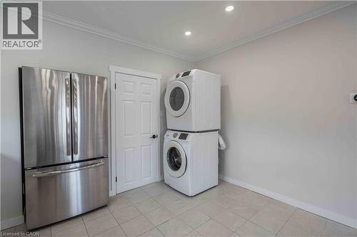Laundry area featuring tile flooring, white baseboards, and crown molding - 204 Glow Avenue Unit# Upper, Hamilton, ON 