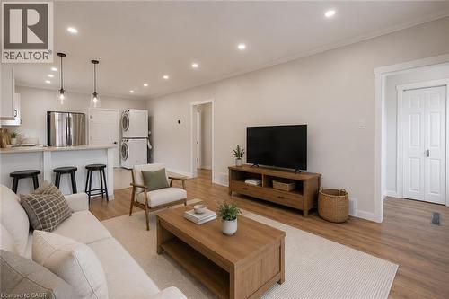 Open-concept living area with wood-finish flooring, recessed lighting, and a neutral color palette - 204 Glow Avenue Unit# Upper, Hamilton, ON 